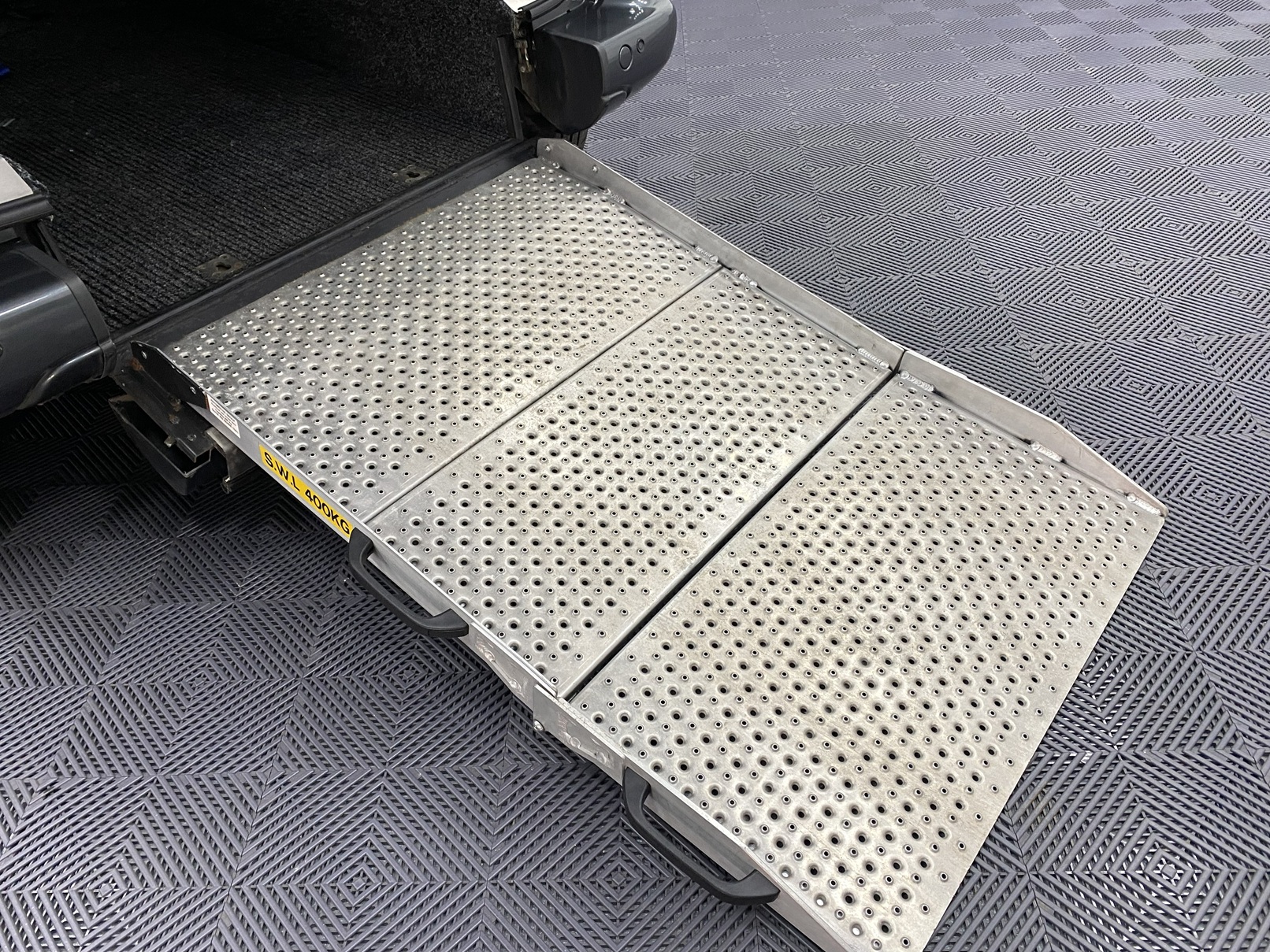 A rear wheelchair ramp folded out on wheelchair accessible accessible (WAV) Citroen Berlingo that is for sale at Michael Harraway Cars in Weston super Mare NK68 AYF 10