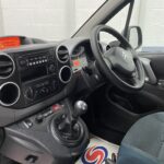 The central dashboard controls and steering wheel on a wheelchair accessible Citroen Berlingo that is for sale at Michael Harraway Cars NK68 AYF 14