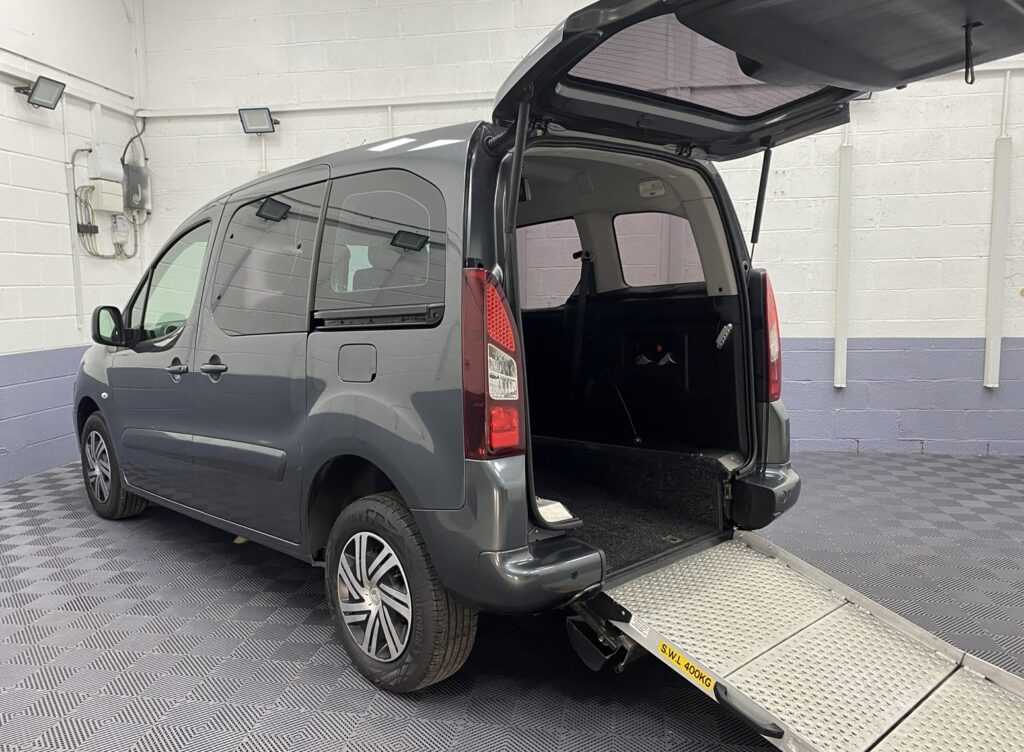 A Grey wheelchair accessible accessible (WAV) Citroen Berlingo that is for sale at Michael Harraway Cars in Weston super Mare Rear side view with boot open and rear ramp folded out NK68 AYF 9