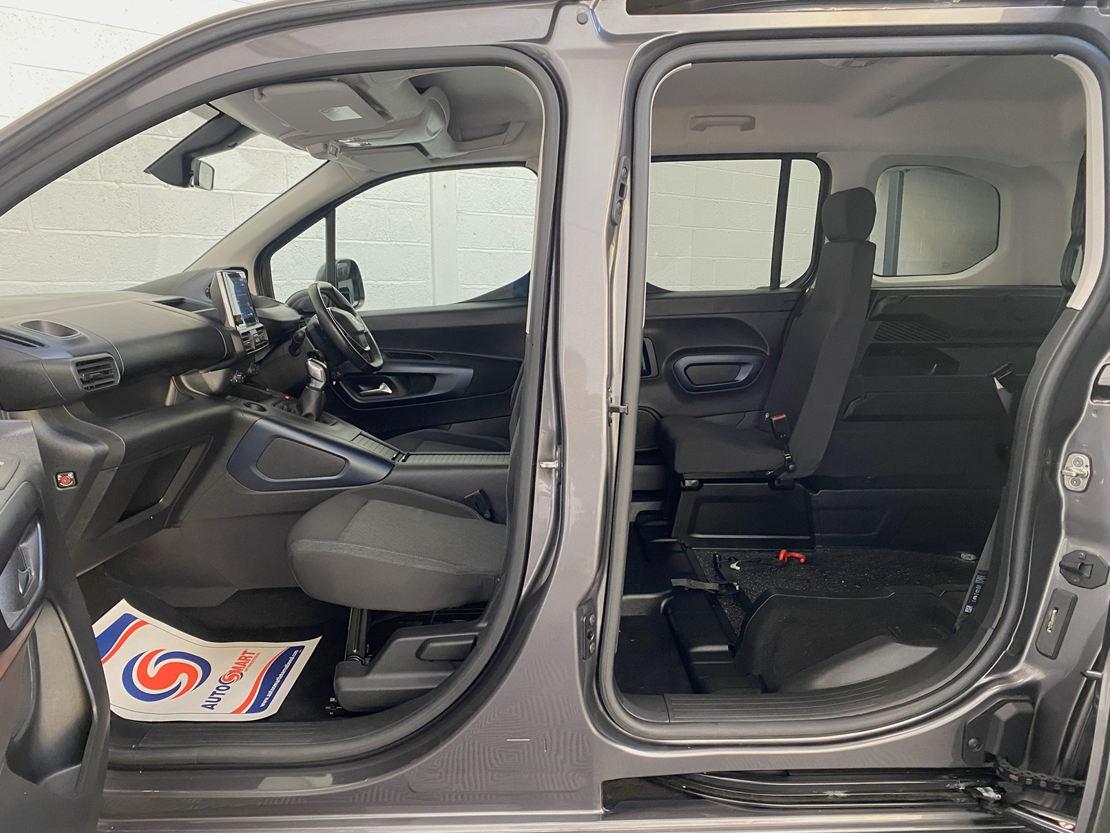 Peugeot Rifter WAV wheelchair accessible vehicle for sale at Michael Harraway Cars, Weston-super-Mare, with three passenger seats, space for one wheelchair user, and a lightweight fold-flat rear access ramp. SF20 GNP19