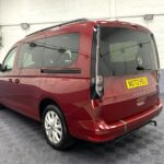New shape Volkswagen Caddy Maxi in metallic Red that has been adapted to carry a wheelchair passenger. ND72 HOJ 1
