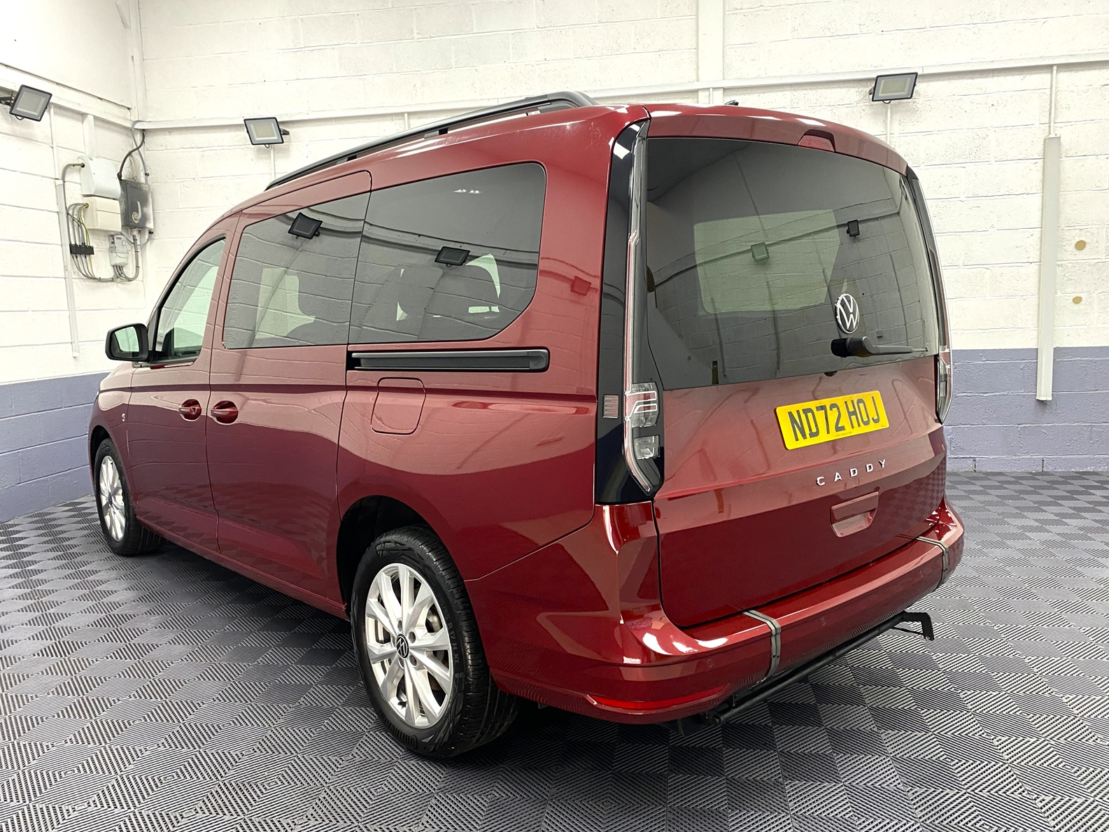 New shape Volkswagen Caddy Maxi in metallic Red that has been adapted to carry a wheelchair passenger. ND72 HOJ 1