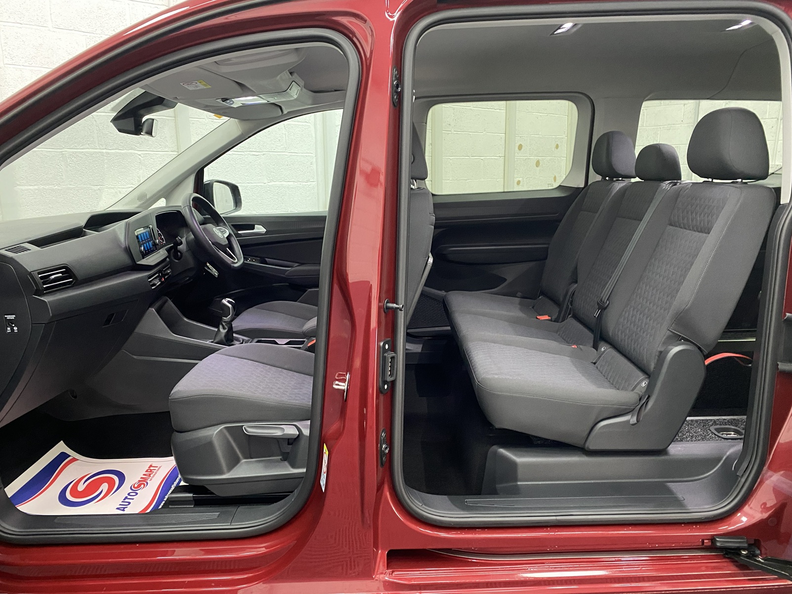 New shape Volkswagen Caddy Maxi in metallic Red that has been adapted to carry a wheelchair passenger. ND72 HOJ 1
