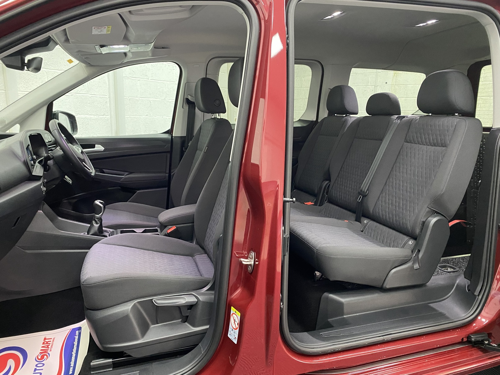 New shape Volkswagen Caddy Maxi in metallic Red that has been adapted to carry a wheelchair passenger. ND72 HOJ 13