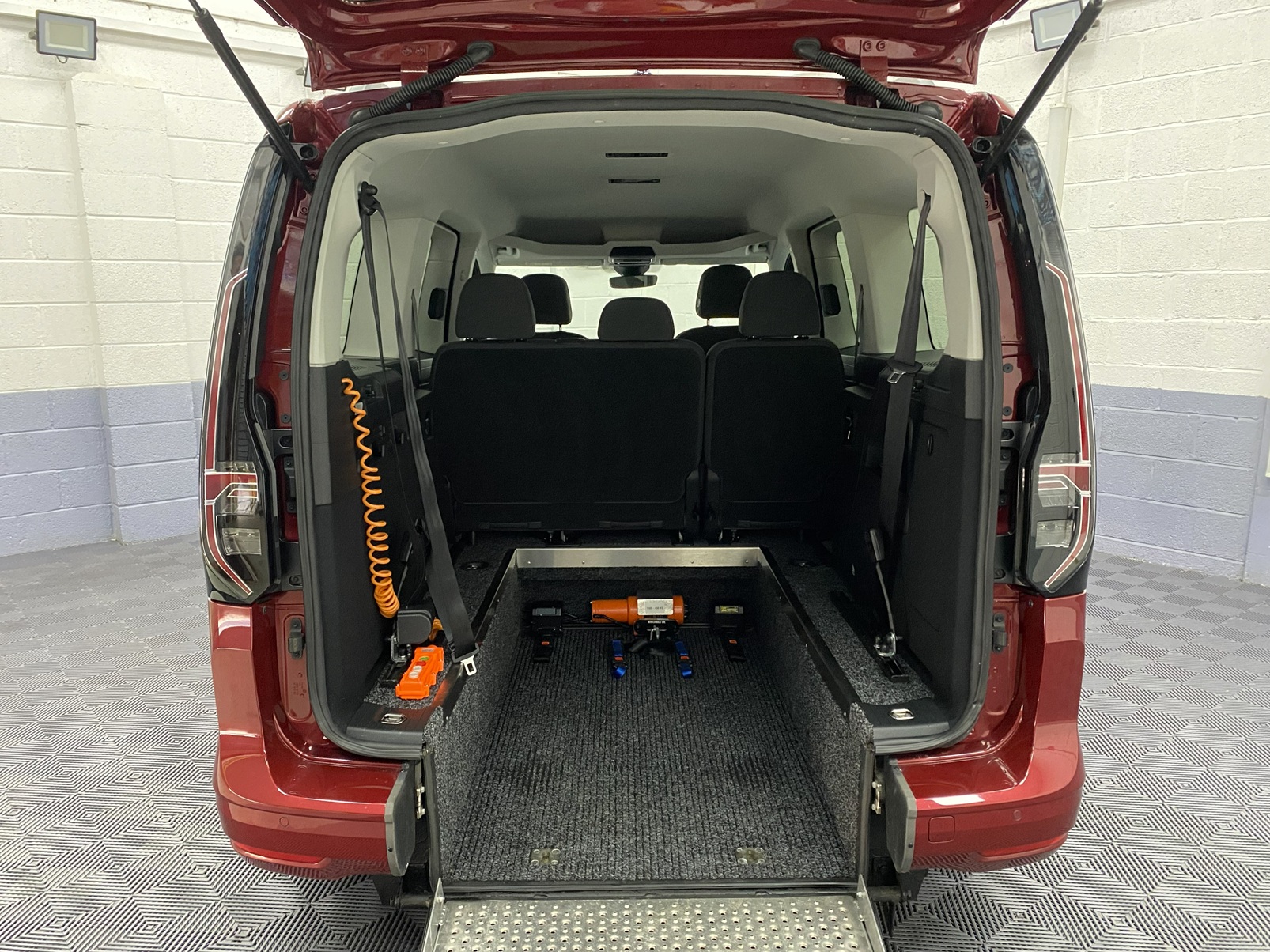 New shape Volkswagen Caddy Maxi in metallic Red that has been adapted to carry a wheelchair passenger. ND72 HOJ 7