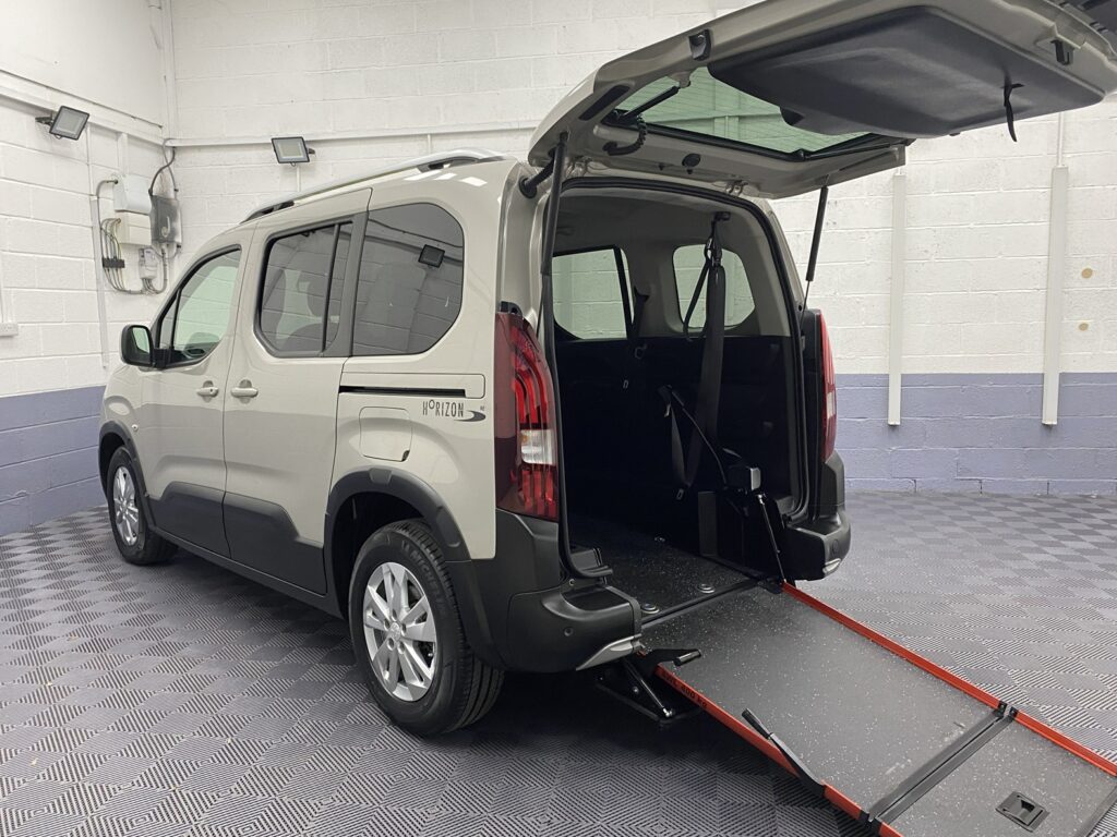 2020 Beige Peugeot Rifter wheelchair accessible vehicle rear three quarter view with the rear wheelchair ramp deployed. SF70 KNX