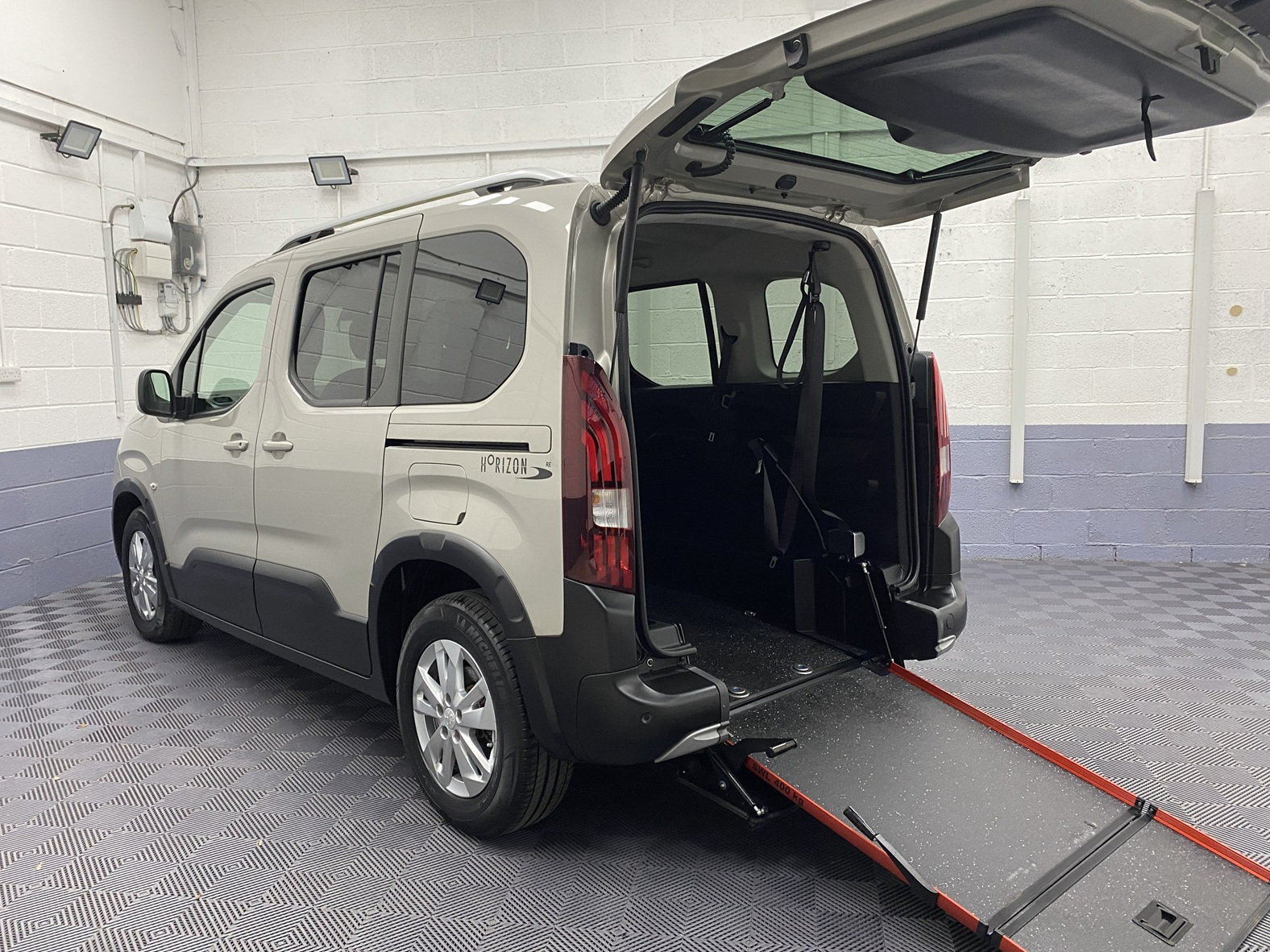 2020 Beige Peugeot Rifter wheelchair accessible vehicle rear three quarter view with the rear wheelchair ramp deployed. SF70 KNX