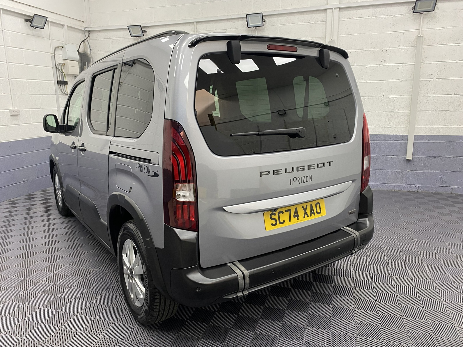 2025 grey Peugeot Rifter rear three quarter view zoomed SC74 XAO