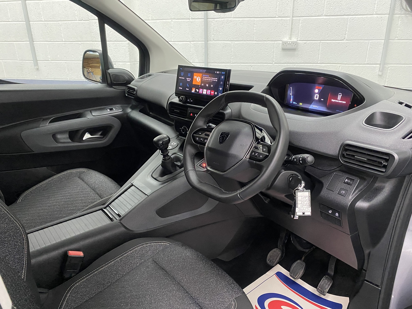 2025 Peugeot Rifter interior from drivers door view showing the steering wheel and dashboard SC74 XAO